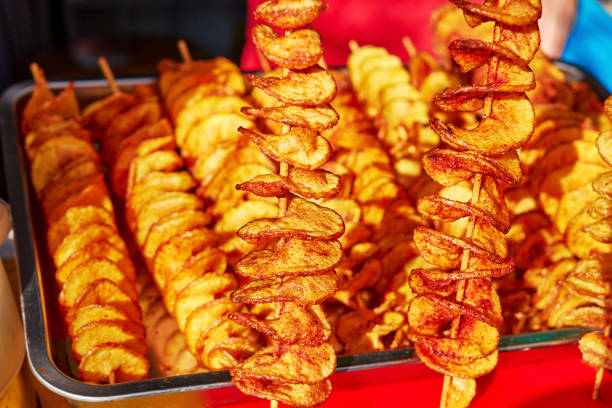 potatoes cut into a spiral and fried. tornado potato potatoes cut into a spiral and fried. tornado potato. street food. close-up photo bamboo twist stock pictures, royalty-free photos & images