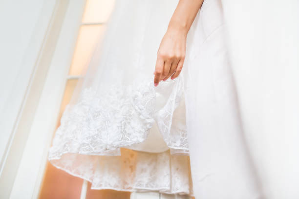 istock Brides dress and hand on wedding day 1399062445