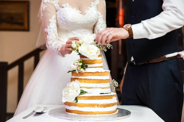 istock Bride and groom and multilevel wedding cake with flowers 1399062498