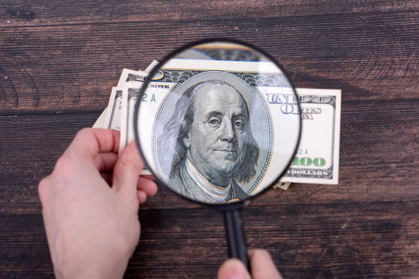 istock A $100 bill through a magnifying glass, Benjamin Franklin close-up. 1399067849