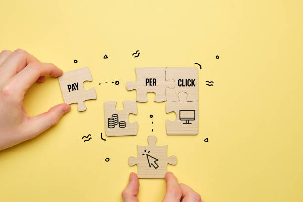 Concept Pay per click or PPC. The person puts together a puzzle of text and icons. stock photo