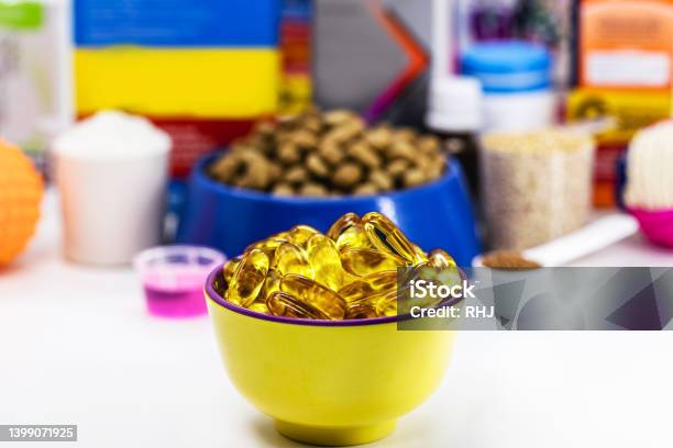 Bowl With Omega 3 Capsules And Pet Food In The Background Veterinary Medicine Food Supplement For Dogs Cats Fish Or Birds Stock Photo - Download Image Now