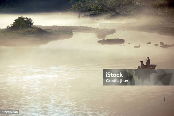 Two People Fishing In A Boat In Misty Water Stock Photo - Download Image Now - Nautical Vessel, Fishing, Sebastinae