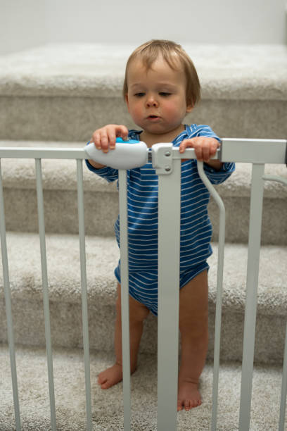 istock Baby boy looking at behind barrier gate at stairs 1399076450