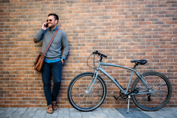 istock Business man with bike using phone 1399076471