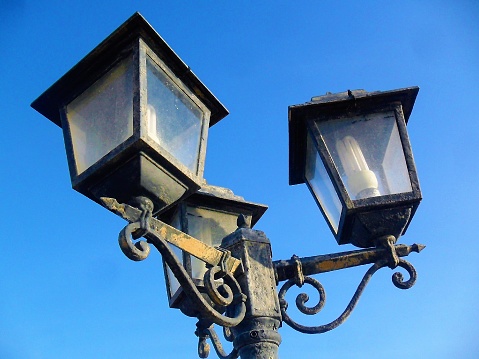 Old gas lanterns, of wrought iron, against the blue sky, in Naples, Italy