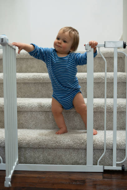 istock Baby boy looking at behind barrier gate at stairs 1399076648