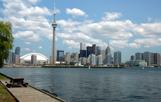 View from western end of Centre Island, showing domed baseball stadium, CN Tower, the financial district, and waterfront condo buildings.   The runway of the City Center airport is visible on the left hand side.