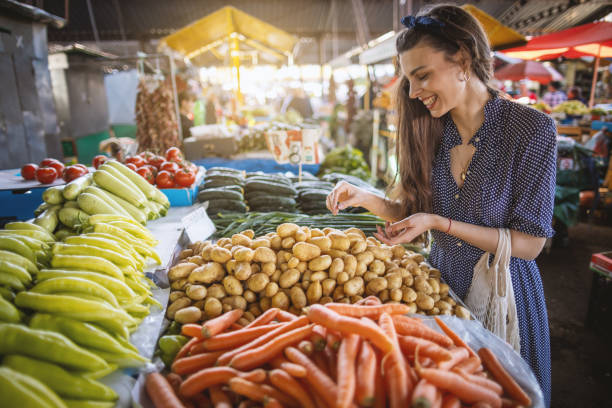 istock Beautiful woman buying fresh vegetables in market 1399077708