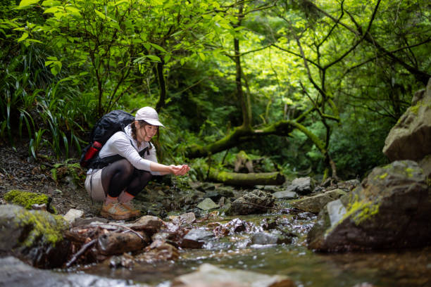 istock Woman washing hands with river water 1399082106