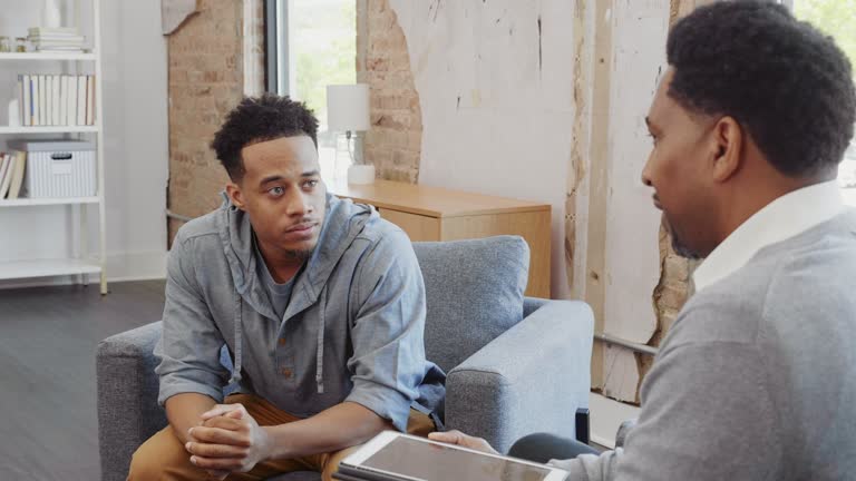 The young adult man and the mature adult male therapist discuss various options and choices.