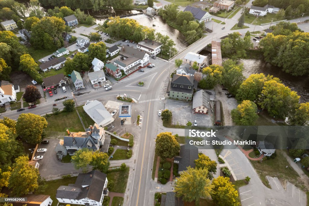 New Hampshire: Aerial view of a small town at sunset Aerial photo of an intersection in a small New England town at sunset with a river. Above Stock Photo