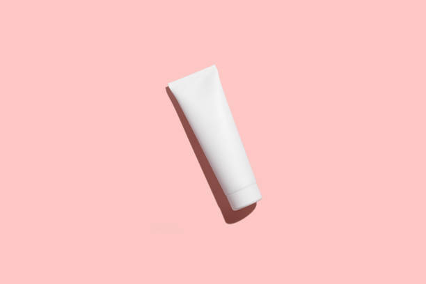 ピンクの背景に隔離された化粧品の白いプラスチックチューブ。モックアップ。 - dental hygiene branding packaging toothpaste ストックフォトと画像