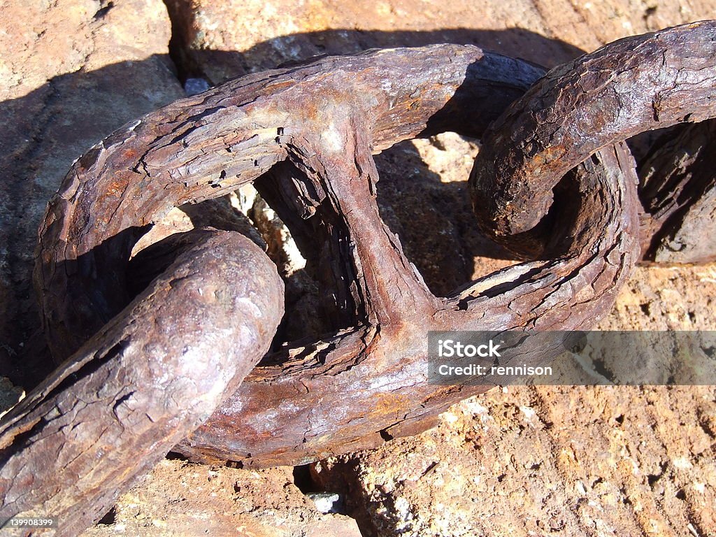 rusted old chain link on concrete boat ramp this is part of an old hold-down chain on a boat ramp. It is rusted Anchor - Vessel Part Stock Photo