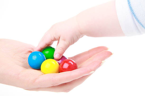 Young child reaching for gumball candy stock photo