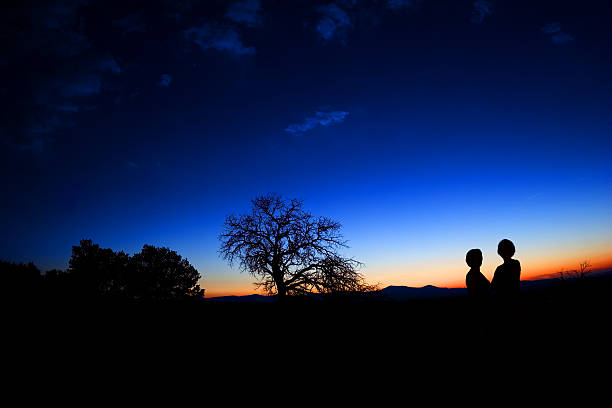 istock Silhouette of two people against beautiful sunset 139909207
