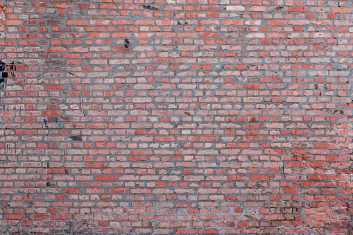 Red brick wall under the damaged concrete wall