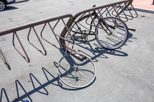 A view of several bike parts left behind on a bicycle rack.