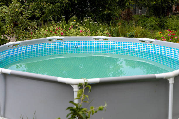 istock Grey frame swimming pool on the green lawn with trees 1399098799