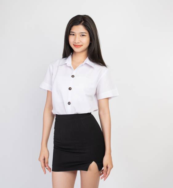 Young Asian female student in school uniform sitting on the staircase in campus.