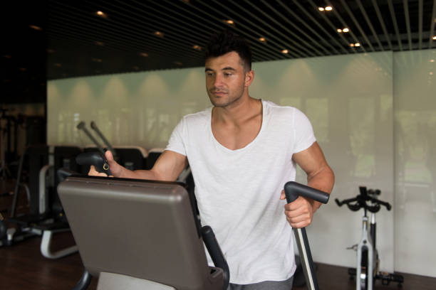 istock Healthy Athlete Doing Aerobics Elliptical Walker In Gym 1399101519