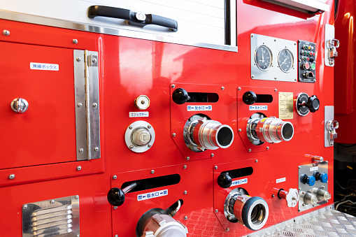 A close up shot of a Japanese fire truck with its hose outlets, levers and buttons to control the water flowing from the truck to put out fires.