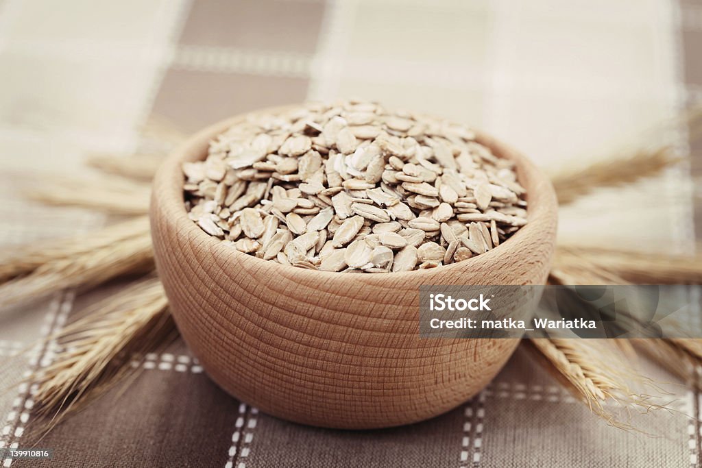 wild oats bowl full of rolled oats - food and drink Bowl Stock Photo