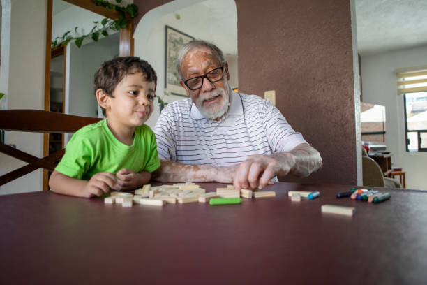 Photo of grandparents and grandsons playing board game together