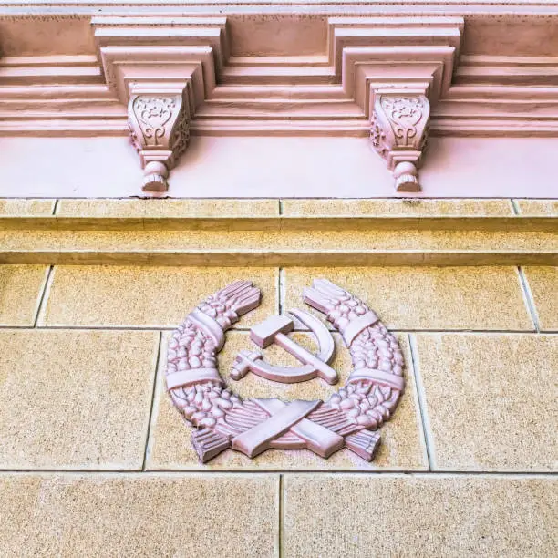 Photo of USSR coat of arms in the architecture, communist emblem, relief, sickle, hammer, wheat