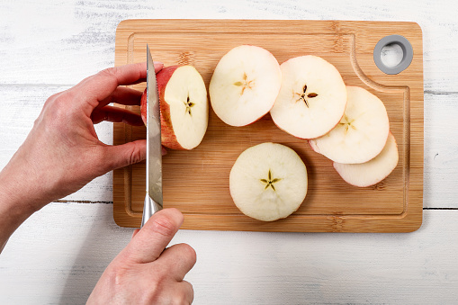 Cut apples on a cutting board. Sharp knife.