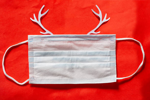 istock Festive christmas reindeer made from face mask on red background 1399124601