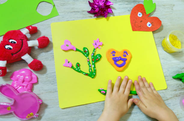 紙と粘土、プラスティシンから面白い工芸品を作る子供。母の日、誕生日やバレンタインデーの贈り物として花や心。アートクラフトのコンセプト。 - oeuvre ストックフォトと画像