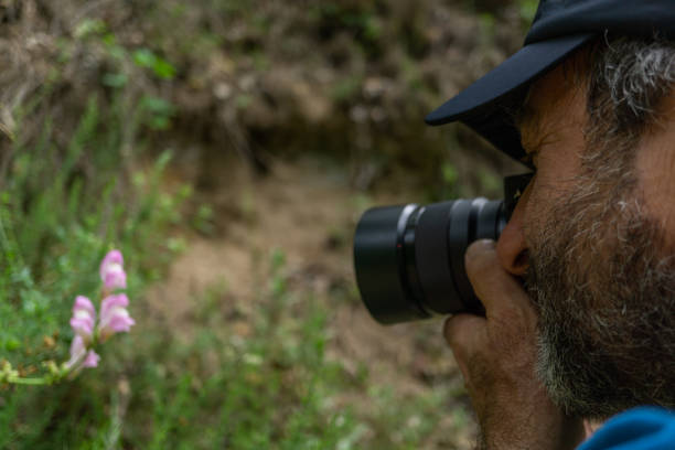 istock man with beard and cap taking a picture of a flower 1399129366