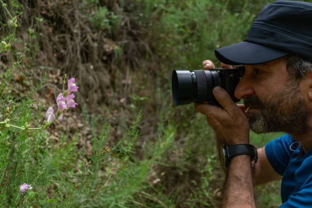 istock man with beard and cap taking a picture of a flower 1399129371