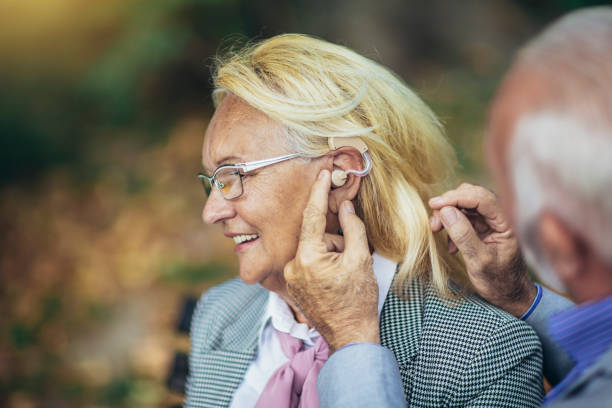 istock Senior couple with a hearing problem sitting on bench outdoor 1399130127