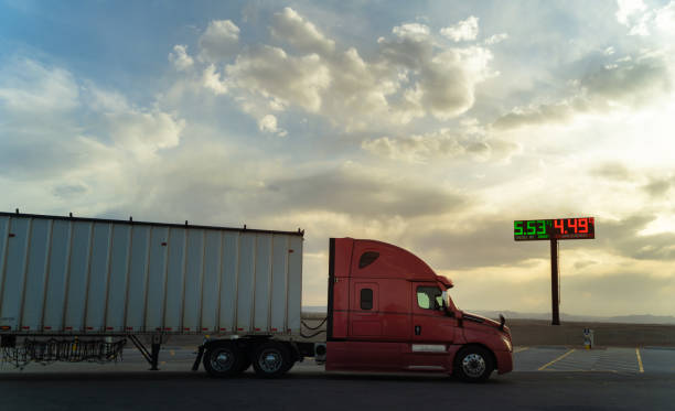 semi truck passing in front of a gas price sign at resting area - station in utah - pumping up fotos imagens e fotografias de stock
