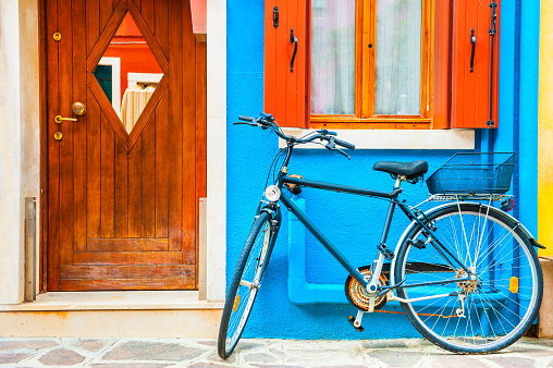 Bicycle parked near the blue-painted house. Colorful architecture in Burano island, Venice, Italy.