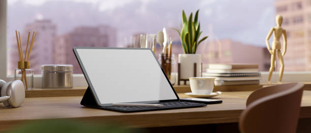 istock Office desk workspace with portable tablet mockup on table over blurred building view in background. 1399137561