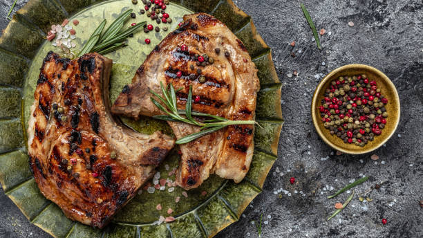 istock Grilled pork chops with rosemary on dark background. Top view, banner, copy space 1399137937