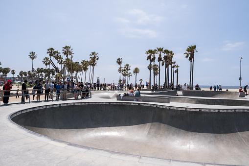 Venice Beach, Los Angeles, California - February 25 2018: Skater jumping at Venice Beach skatepark at a sunny day