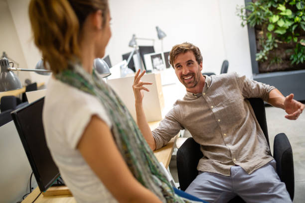 Happy diverse design professionals communicating while working in the office.