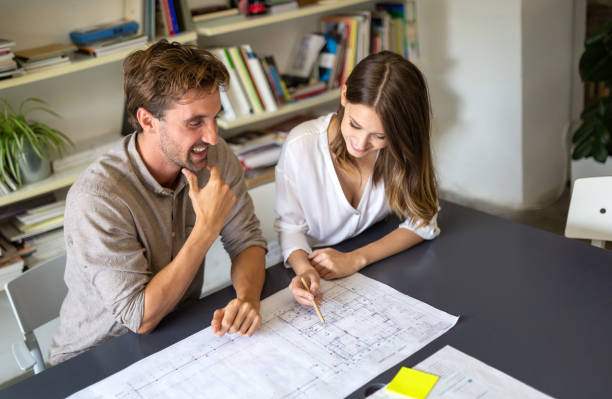 istock Group of business people on meeting with construction engineer architect looking blueprint plans 1399139244