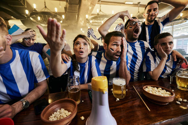 istock Sports fans feeling disappointed while watching a game on TV in a pub. 1399140875