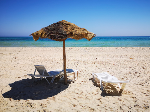 Blue seas and sandy beach in Hammamet. Holiday sunbathing concept in Tunisia.