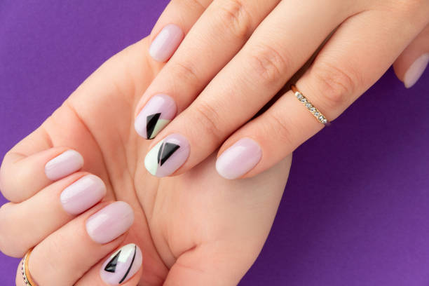 istock Close up womans hand with creative nail design on violet background 1399147254