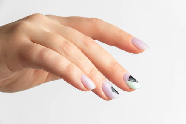 istock Close up womans hand with creative nail design on grey background 1399147324