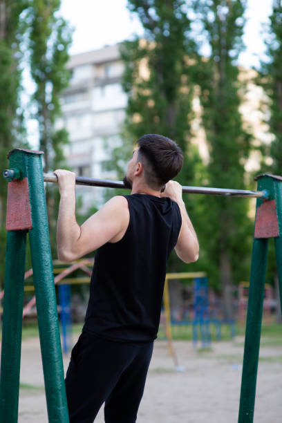 istock A male athlete pulls up on the horizontal bar, rear view 1399148108