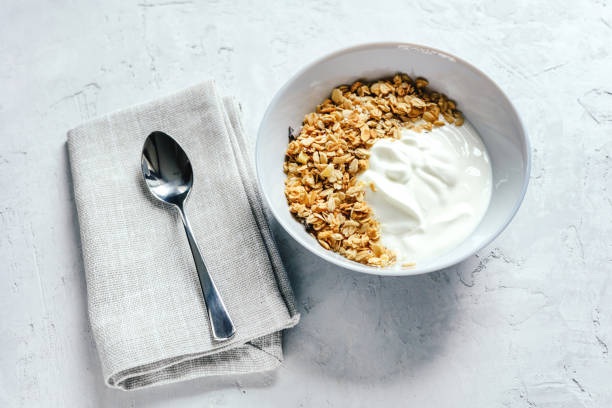 Yogurt with muesli and fresh blueberries on a gray background, perfect breakfast.