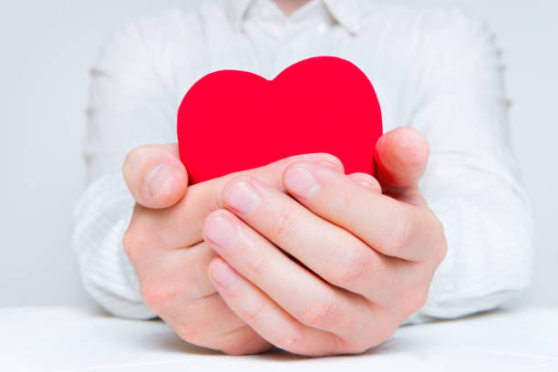 istock Man holding a large red heart in hands 1399149798