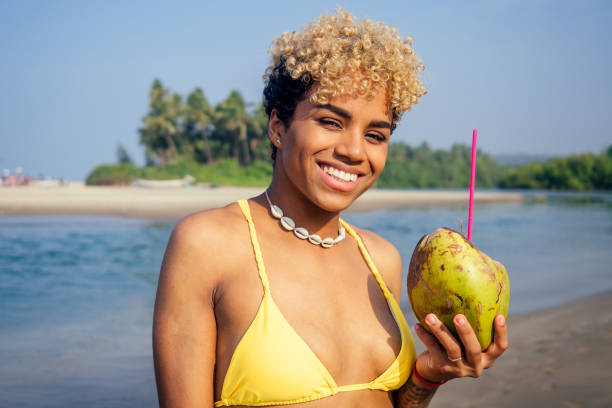 istock hispanic latin beautiful female drinking coco nut water seashells on the neck 1399150818